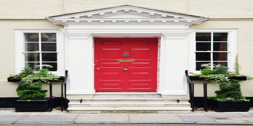 red door with white pillars and windows