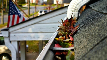 Gutters along a residential roof before and after the leaves trapped inside have been removed with a gutter cleaning service from Mr. Handyman.