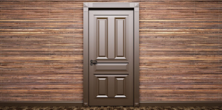 A closed brown door viewed from the interior of a residential room with walls made of thin wood strips.