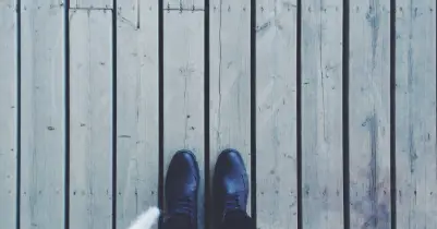 A pair of black shoes on a wooden deck.