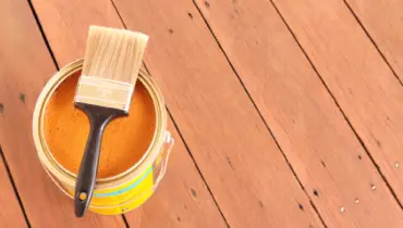 Photo of yellow paint bucket on a wooden deck