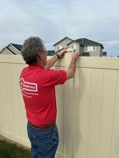 Mr. Handyman service professional working on a fence.
