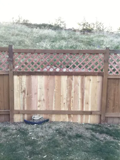 Newly installed image with the bottom two-thirds of fence in vertical slats and the top third is a criss-cross pattern.