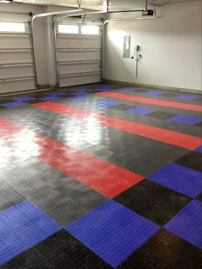 An image of black, red, and blue rubber tiles arranged in a pattern to create full coverage flooring in a garage.
