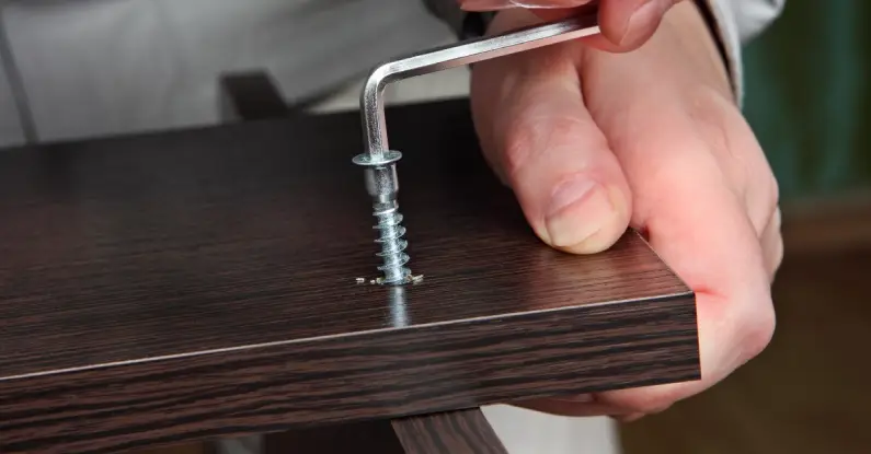 A close-up of a handyman’s hand as they use an Allen key to join two pieces of wood with a screw during an appointment for assembly service in Frisco, TX. 