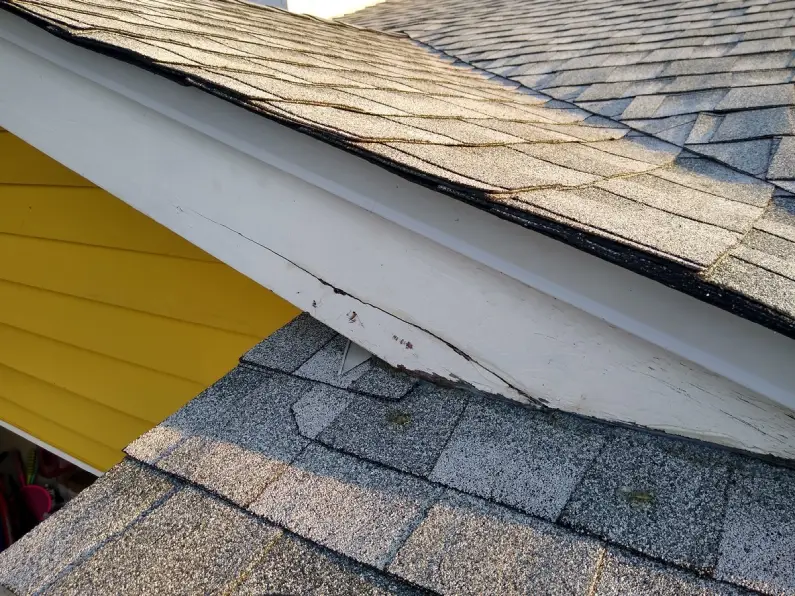Cracked and rotted fascia board along the roofline of a home in need of wood rot repairs.