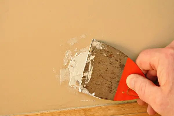 Handyman using putty knife to repair drywall in Cincinnati home