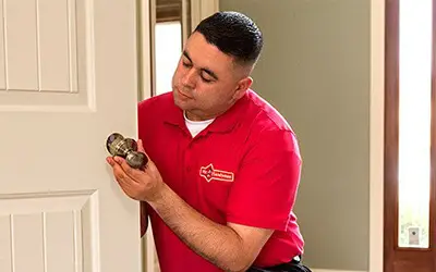 A Mr. Handyman craftsman installing a door knob