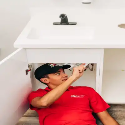 Handyman under a sink.