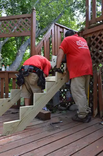 Two Mr. Handyman technicians fixing deck stairs during National Day of Service.