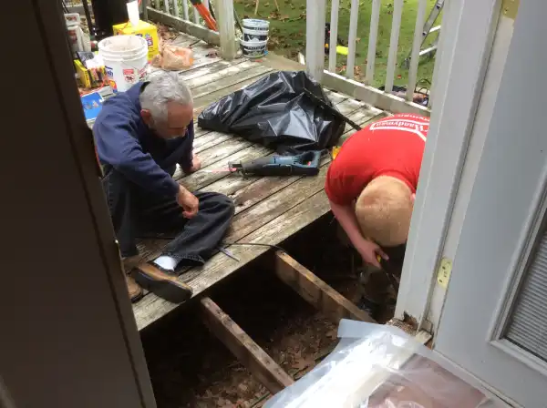 Two Mr. Handyman technicians repairing wood deck.