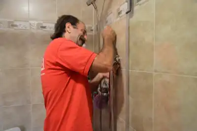 Mr. Handyman technician fixing shower.