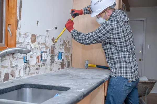 Renovation Worker Removing Kitchen Wall Tile 