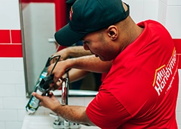 My Handyman worker caulking around sink.