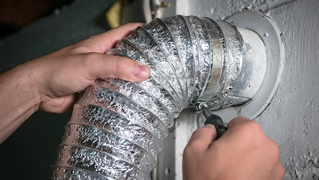Mr. Handyman repairing dryer vent.