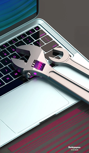 Two wrenches of differing sizes on a laptop.