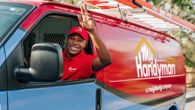 My handyman technician waves from a service van.