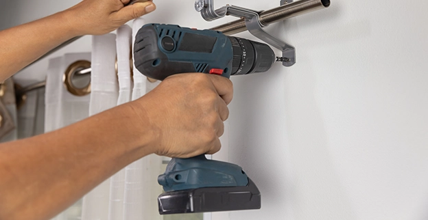 A picture of a drill installing curtain rods.