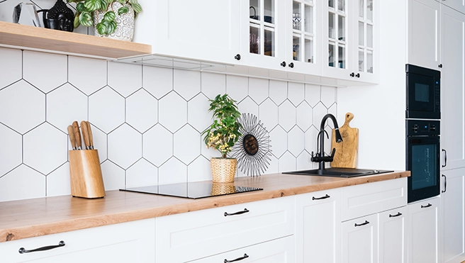 A picture of white kitchen custom cabinets.