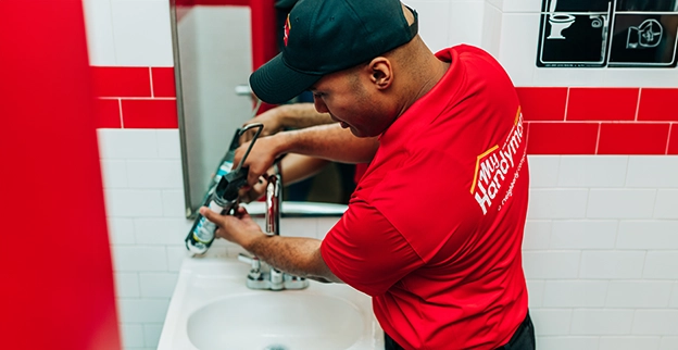MRH employee repairing a washbasin.