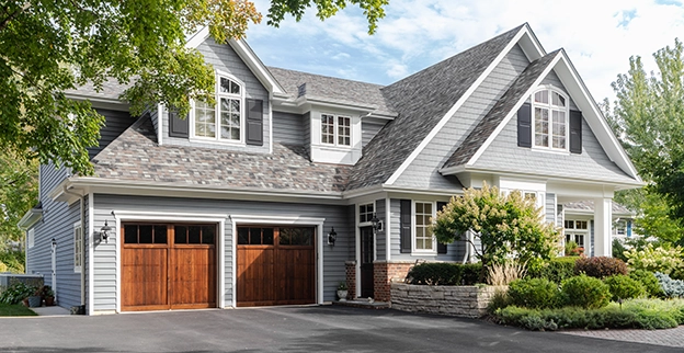 A house with two wooden garage doors.