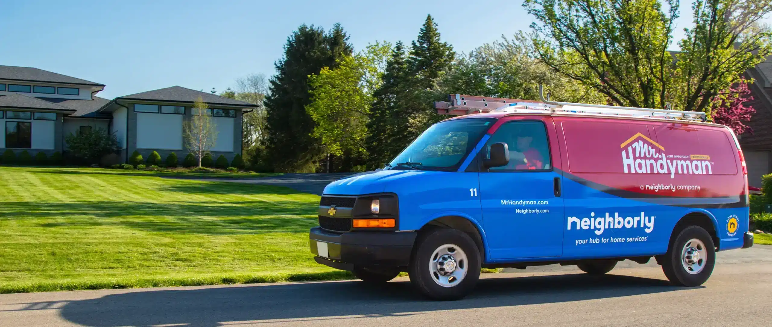 Mr. Handyman service van driving through a residential neighborhood.