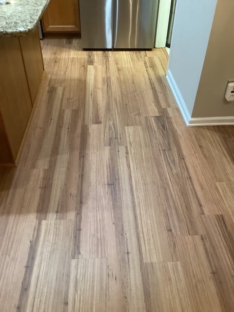 Kitchen walkway featuring fresh wood plank flooring installation