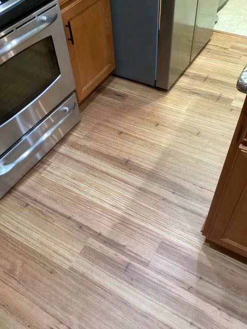 Stainless steel appliances and new wood floors in remodeled kitchen