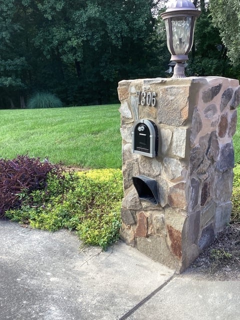 Restored stone mailbox with new address numbers and mounted light fixture