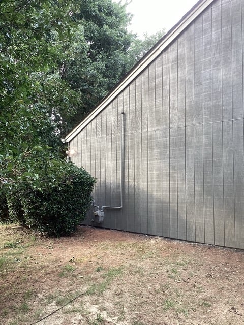 New siding installation in progress with ladders and tools on site