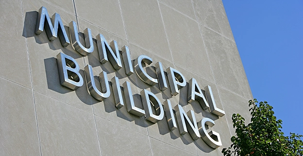 Close-up of the sign reading Municipal Building with a grey painted background.
