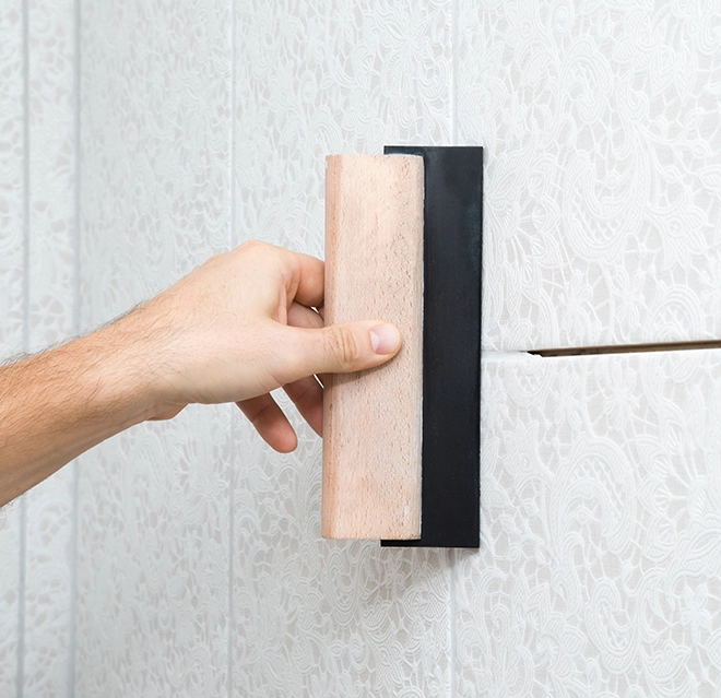 Applying grout using rubber trowel.
