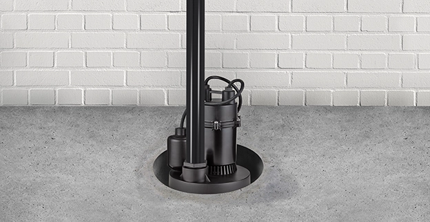 Black sump pump installed in a concrete basin for managing water drainage.