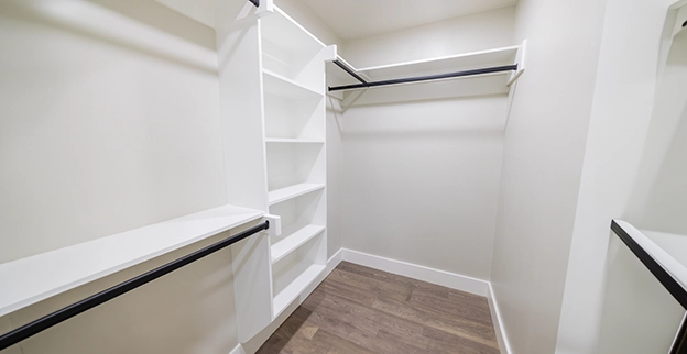 A spacious walk-in closet with white shelves