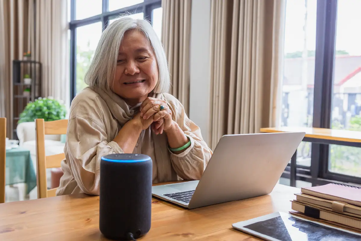 An older adult using a voice assistant in their home.