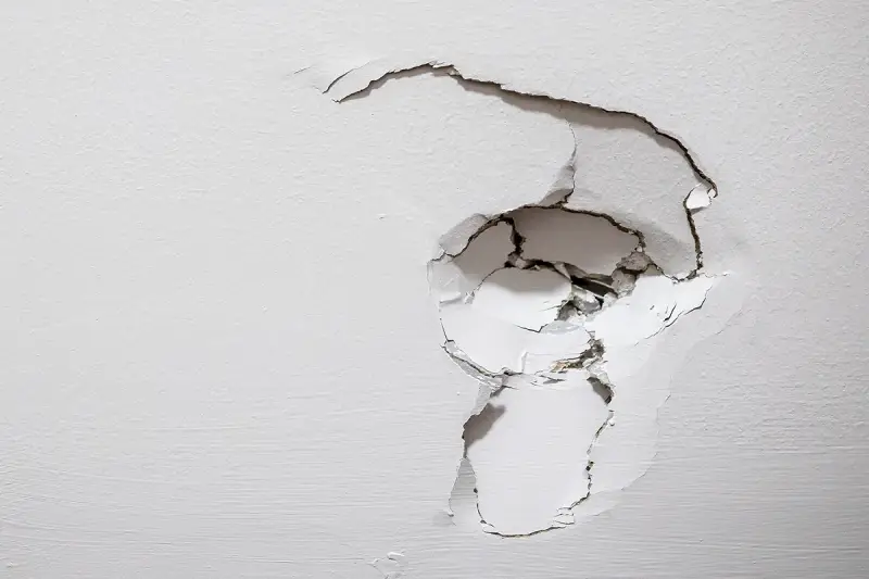 Image of damaged drywall with a large dent.
