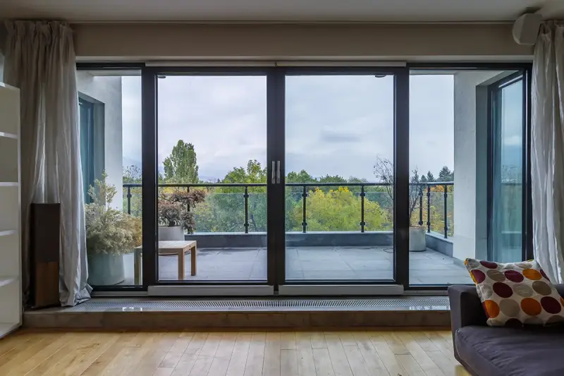 A home with a glass sliding door leading to a balcony.
