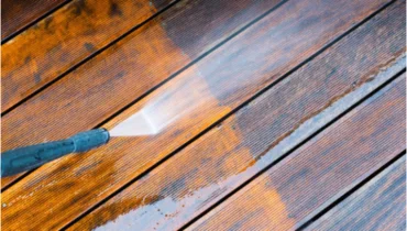 Handyman providing pressure washing service for residential homes deck.