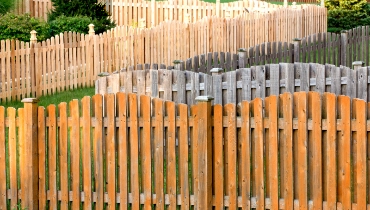 Several rows of different fences near each other, some of which have damage or wear that can be fixed with professional fence repair.