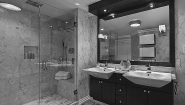 Black-and-white image of bathroom with walk-in shower.