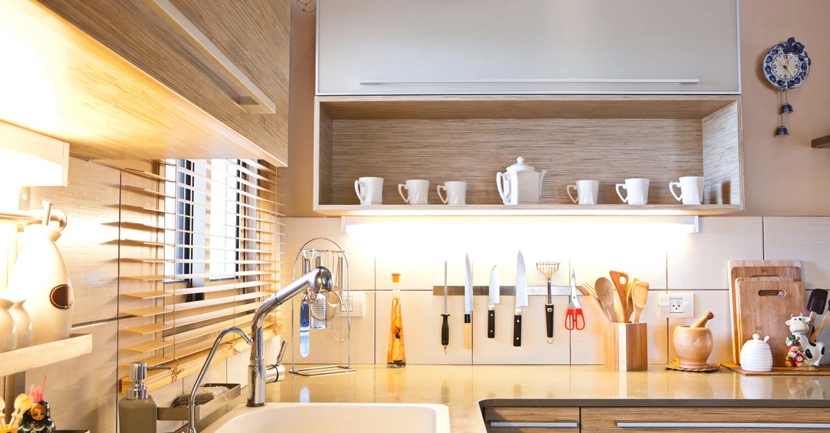 A completed kitchen remodel with open shelving below the upper cabinets, a white backsplash, and a magnetic knife rack.