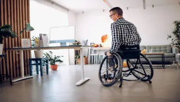 Man in a wheelchair in his home office