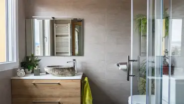 A simple, modern bathroom is shown with a sink, toilet, and shower.