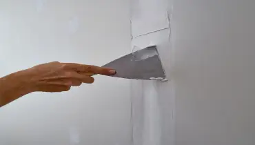 A handyman repairing drywall