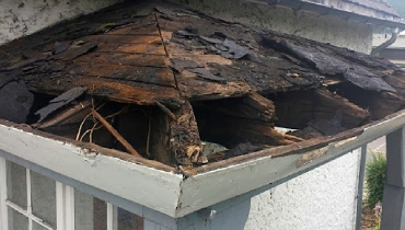 An exposed, damaged, residential roof in need of professional wood rot repair.