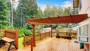A spacious deck with an attached pergola that has been well-maintained with professional pergola repairs.