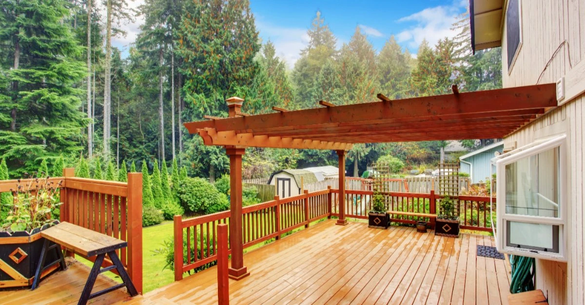 A spacious deck with an attached pergola that has been well-maintained with professional pergola repairs.