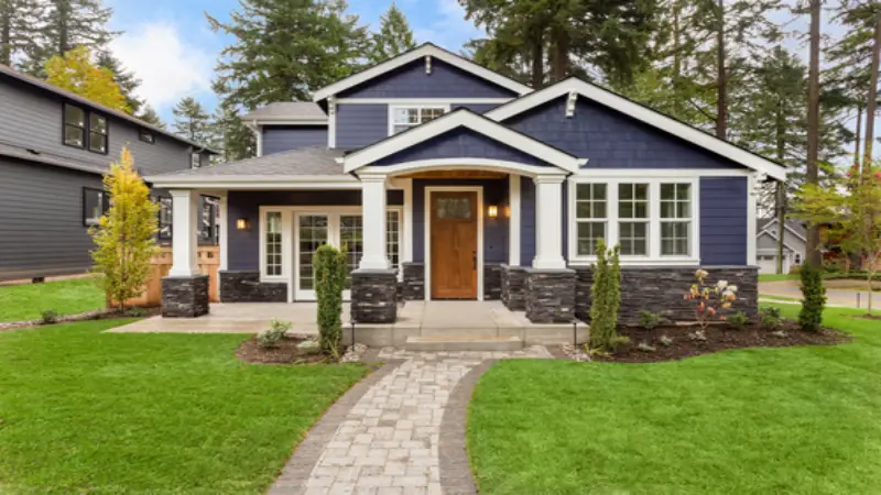 Photo of the front of a blue house with white trim