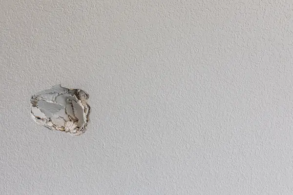 A hole in a wall that requires drywall repair.