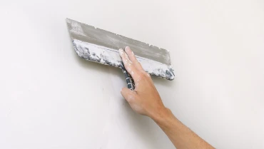 Handyman using a trowel in a wall for drywall repair in west chester
